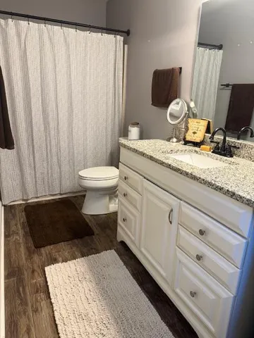 a bathroom with a granite countertop sink toilet and shower