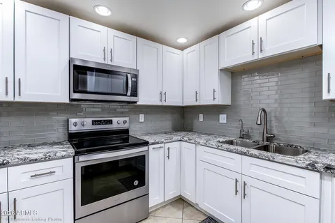 a kitchen with granite countertop cabinets stainless steel appliances and a sink