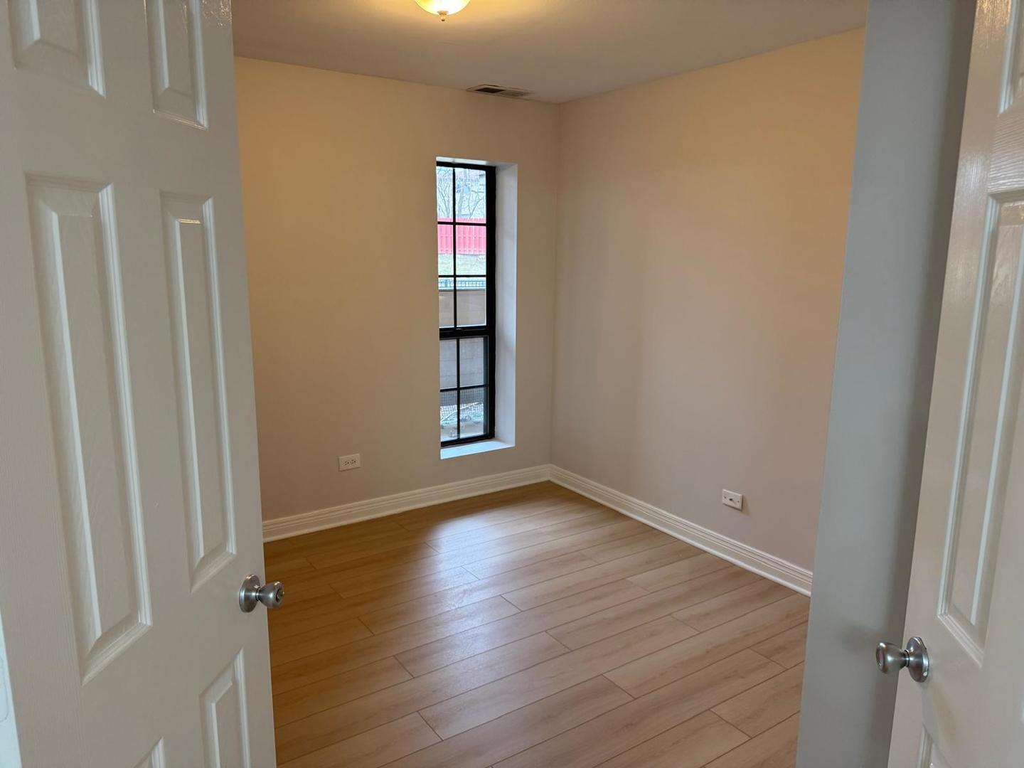 1935 North Hicks Road, Unit 106 Palatine, IL 60074 - Photo 9 of 16 an empty room with wooden floor and windows