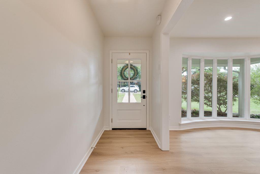 13427 Purple Sage Road Dallas, TX 75240 - Photo 2 of 31 The entry opens with soft natural light through the glass-paneled front door, creating an inviting first step inside.