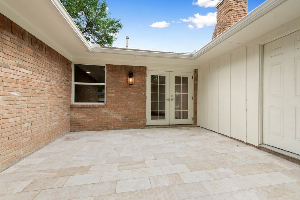 13427 Purple Sage Road Dallas, TX 75240 - Photo 27 of 31 A tiled patio with French doors from the family room extends the living space outdoors, perfect for relaxing or entertaining.
