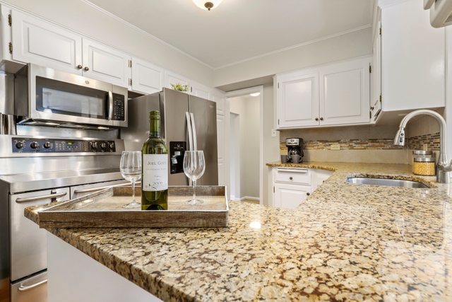 309 East Avenue Park Ridge, IL 60068 - Photo 9 of 32 a kitchen with stainless steel appliances granite countertop a sink stove and refrigerator