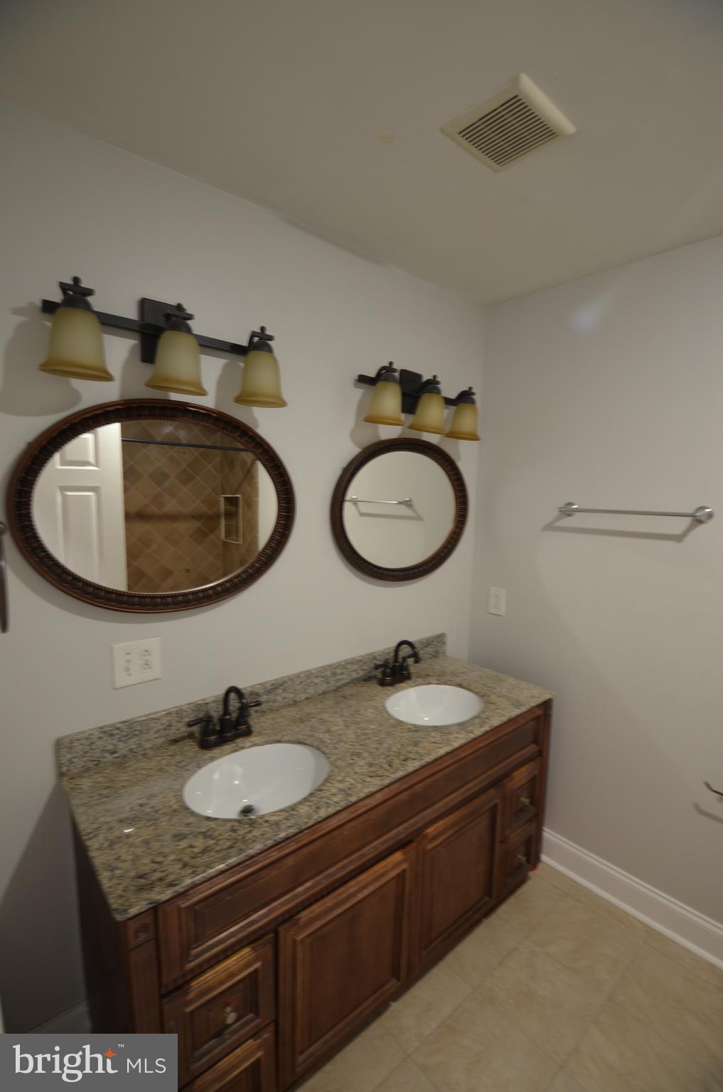 26 North E Avenue Baltimore, MD 21224 - Photo 14 of 22 a bathroom with a granite countertop sink a mirror and a toilet