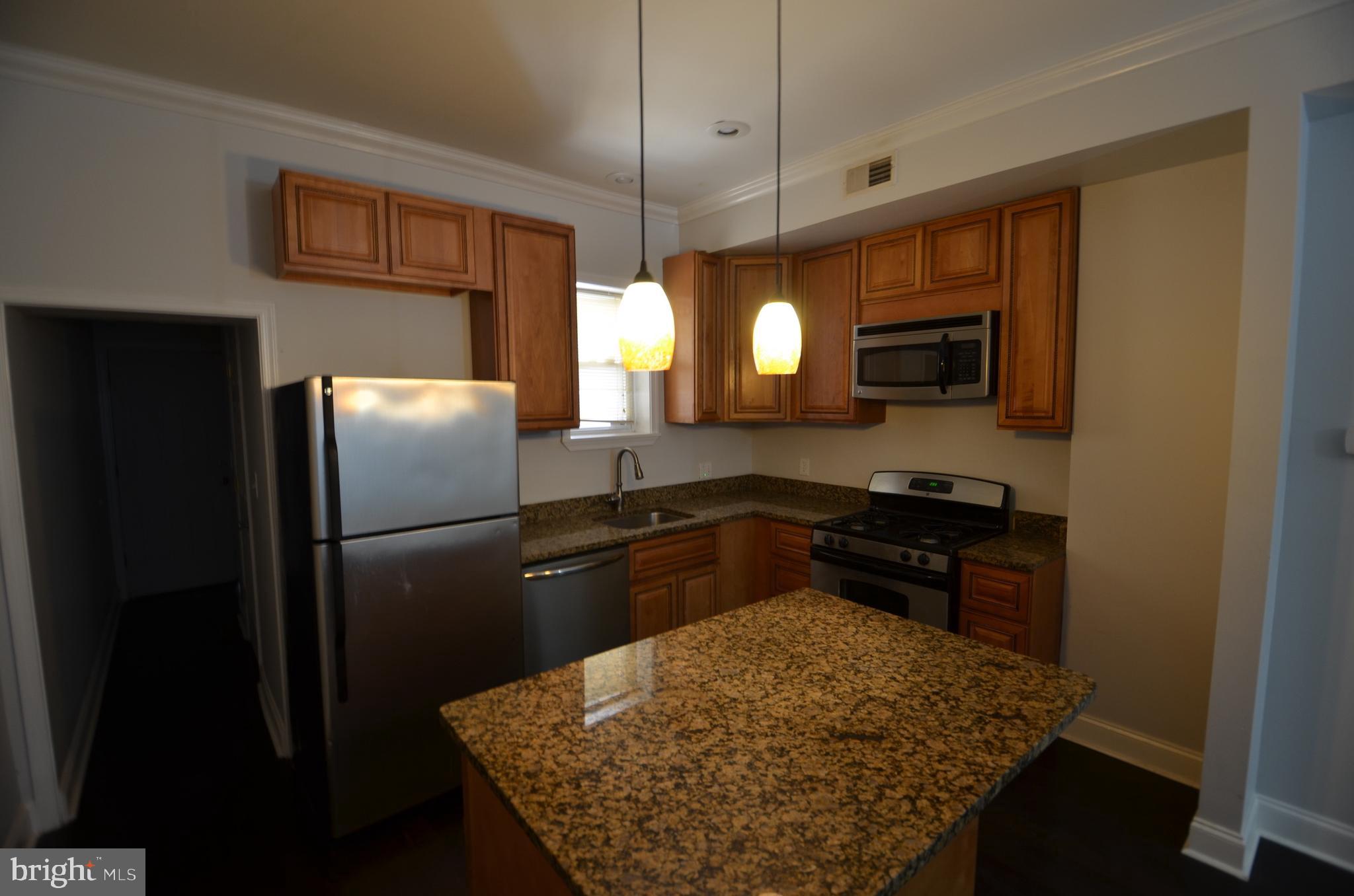 26 North E Avenue Baltimore, MD 21224 - Photo 4 of 22 a kitchen with a refrigerator stove and microwave