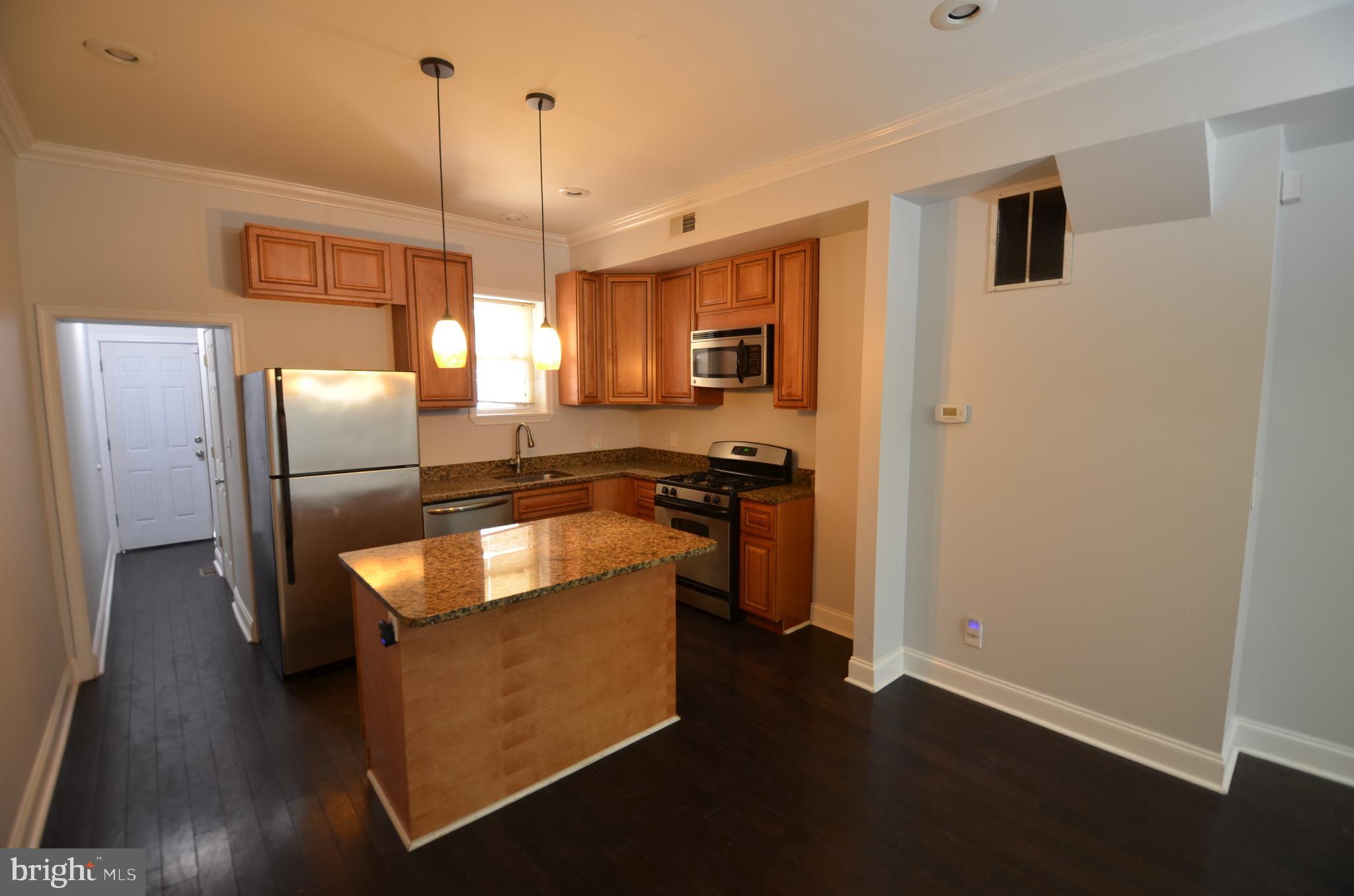 26 North E Avenue Baltimore, MD 21224 - Photo 5 of 22 a kitchen with stainless steel appliances granite countertop a refrigerator a sink and a stove
