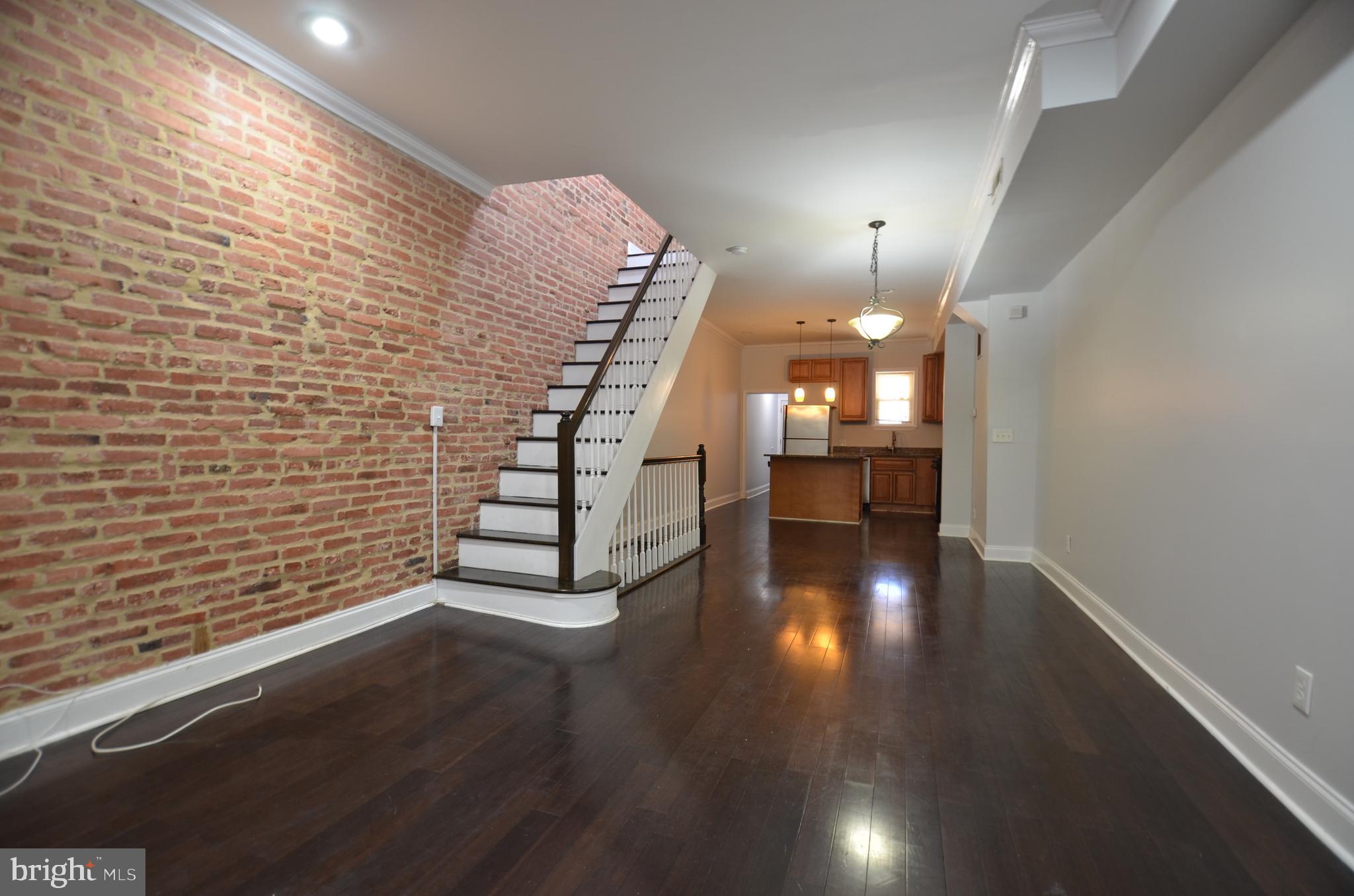 26 North E Avenue Baltimore, MD 21224 - Photo 6 of 22 a view of a room with wooden floor staircase and a kitchen