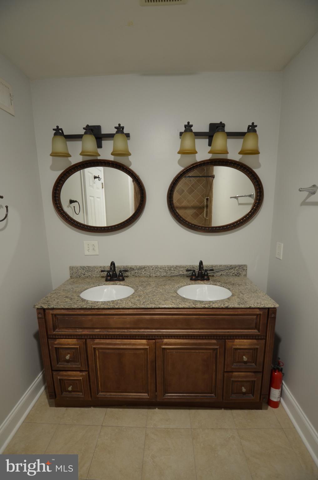26 North E Avenue Baltimore, MD 21224 - Photo 10 of 22 a bathroom with a granite countertop sink and a mirror