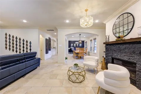 a living room with furniture a fireplace and a chandelier