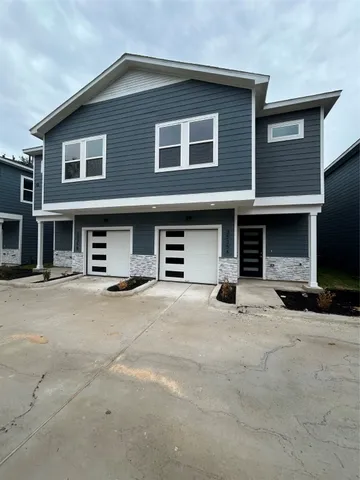 a front view of a house with yard and parking