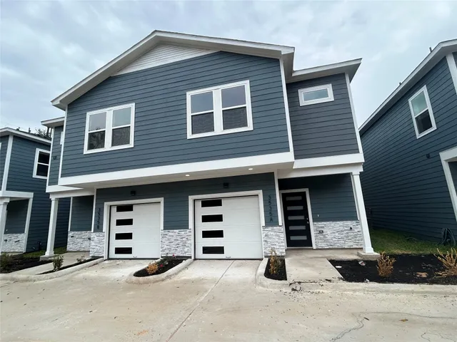 a front view of a house with a yard and parking space