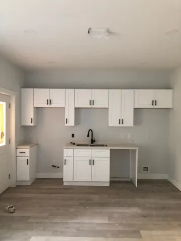 a kitchen with white cabinets and sink