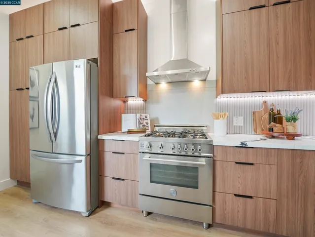 a kitchen with appliances a refrigerator and cabinets