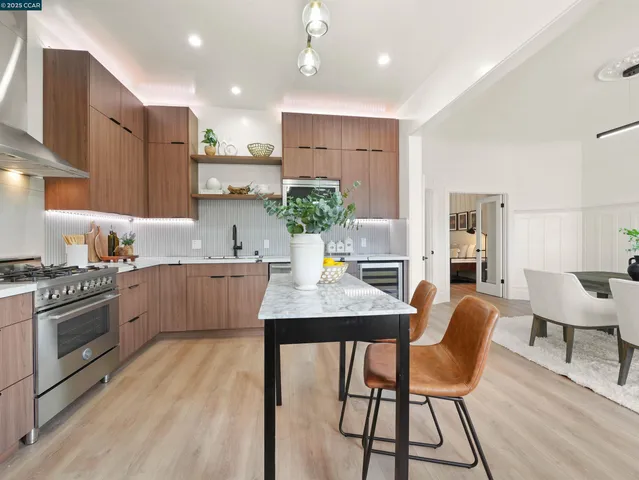 a kitchen with stainless steel appliances granite countertop sink wooden floor dining table and chairs