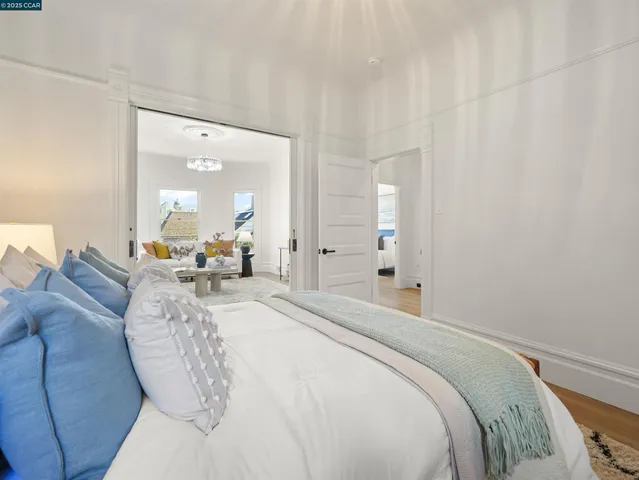 a spacious bedroom with a bed a mirror and lamp