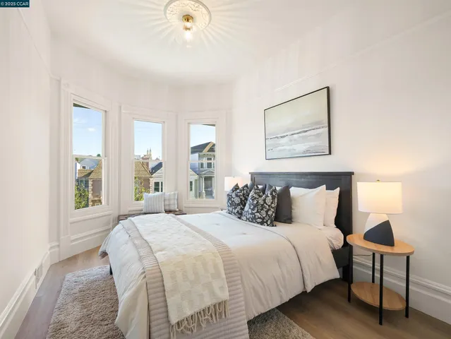 a bedroom with a bed and a painting on the wall