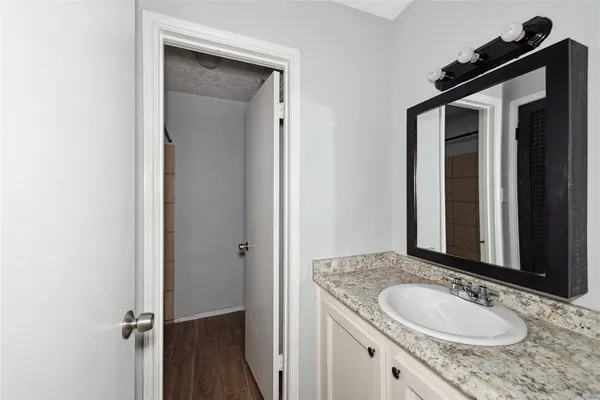 a bathroom with a granite countertop sink and a mirror
