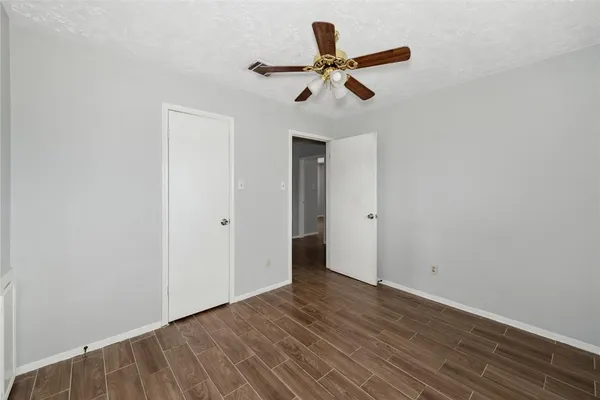 a view of empty room with wooden floor