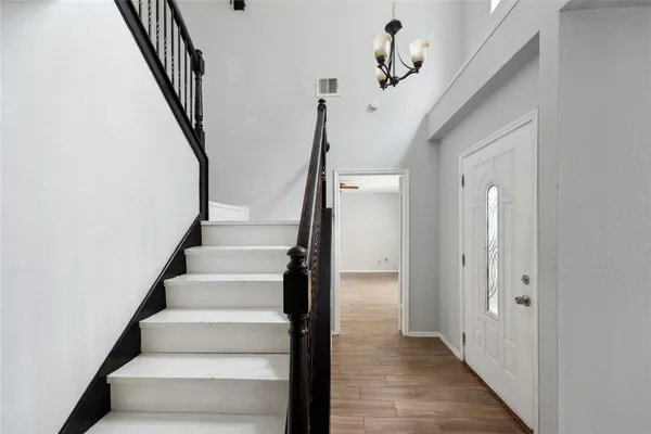 a view of an entryway with wooden floor and staircase