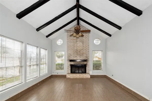 a view of an empty room with a fireplace and a window