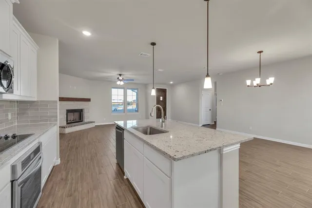 a kitchen with a sink chandelier and wooden floor