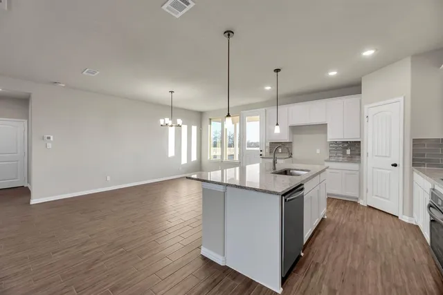 a kitchen with stainless steel appliances granite countertop a sink stove and wooden floor