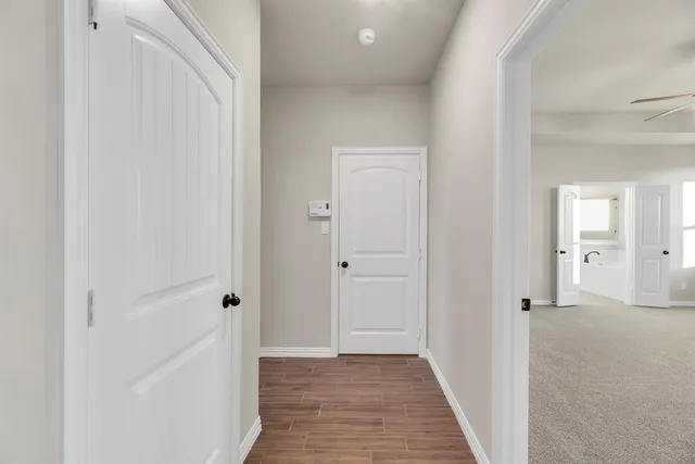 a view of a hallway with wooden floor and closet