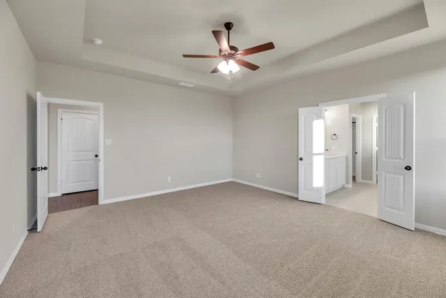 wooden floor in an empty room and a ceiling fan