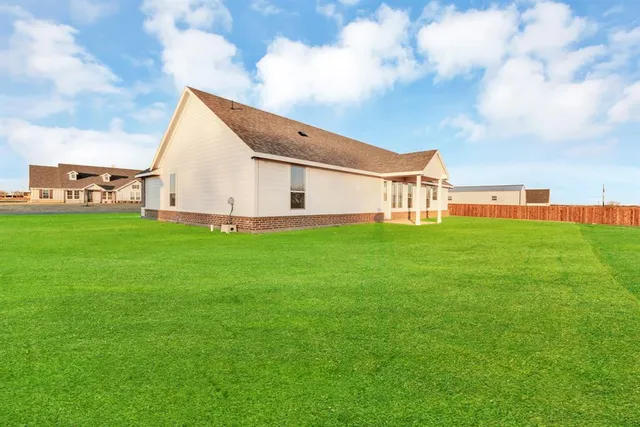a view of a house with a yard and sitting area