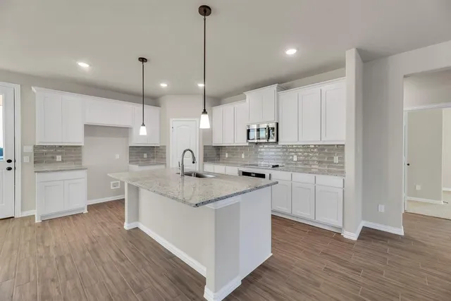 a kitchen with a sink window and stainless steel appliances