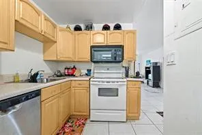 a kitchen with granite countertop a sink a stove and cabinets