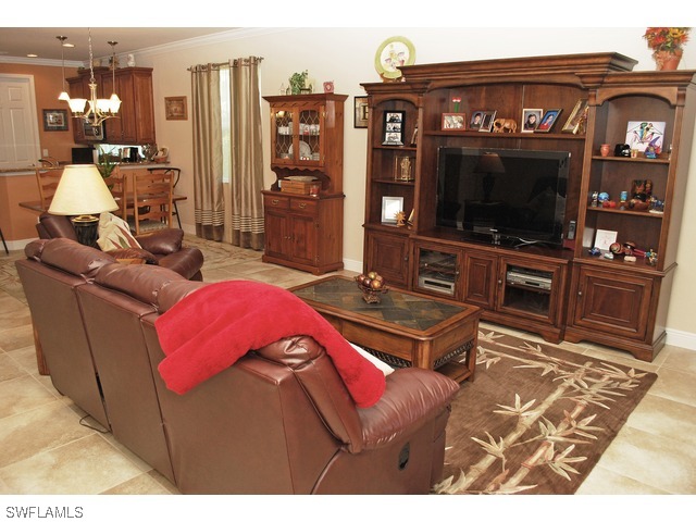 19612 Tesoro Way Fort Myers, FL 33967 - Photo 3 of 14 a living room with furniture a flat screen tv and floor to ceiling window