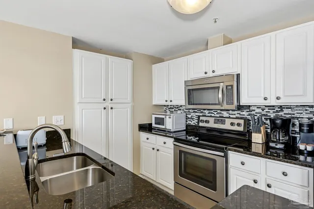 a kitchen with granite countertop a stove and a sink