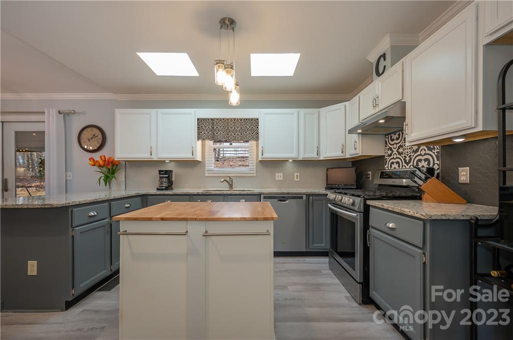 481 Plantation Drive Rutherfordton, NC 28139 - Photo 5 of 48 a kitchen with stainless steel appliances granite countertop a sink stove refrigerator and cabinets