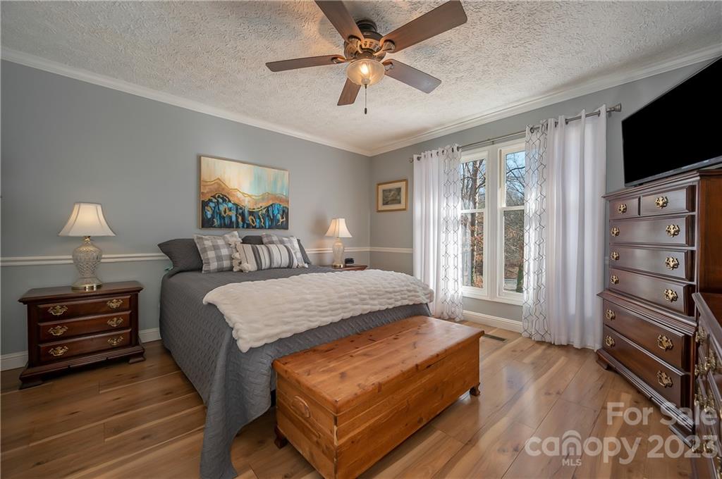 481 Plantation Drive Rutherfordton, NC 28139 - Photo 6 of 48 a bedroom with a bed a flat screen tv and a chandelier