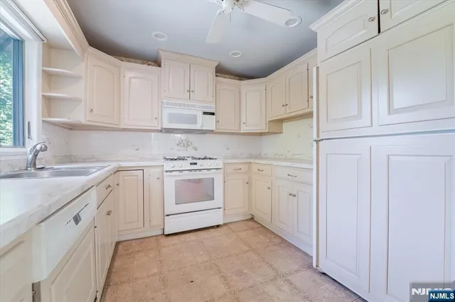 a kitchen with white cabinets appliances and a sink