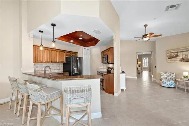 a kitchen with stainless steel appliances kitchen island granite countertop a sink dishwasher stove and cabinets