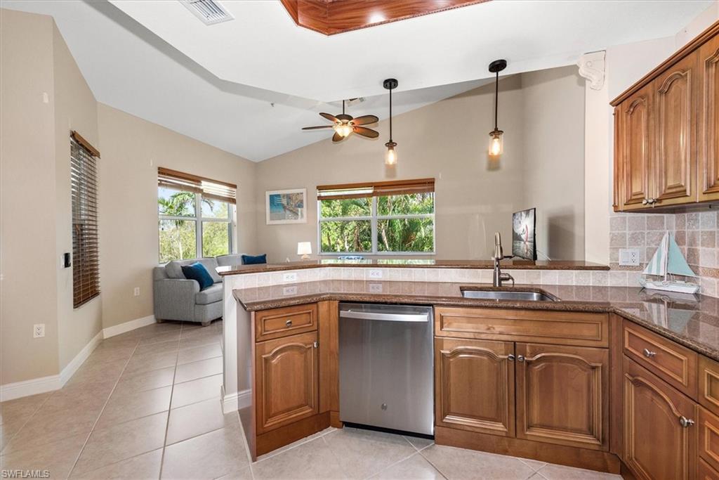 8375 Whisper Trace Way, Unit M203 Naples, FL 34114 - Photo 17 of 36 a kitchen with a sink stove and cabinets
