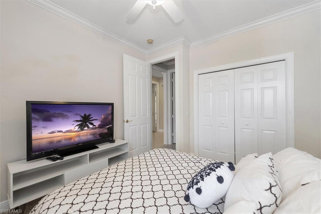 8375 Whisper Trace Way, Unit M203 Naples, FL 34114 - Photo 29 of 36 a bedroom with a bed and a flat screen tv