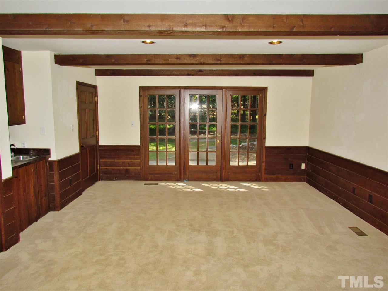 212 Dunstable Court Raleigh, NC 27614 - Photo 13 of 25 a view of an empty room with wooden floor and a kitchen