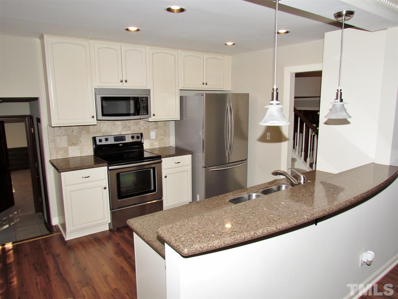 212 Dunstable Court Raleigh, NC 27614 - Photo 9 of 25 a kitchen with stainless steel appliances granite countertop a refrigerator a stove a sink a microwave and white cabinets