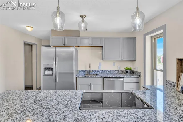 a kitchen with stainless steel appliances kitchen island granite countertop a refrigerator and a stove