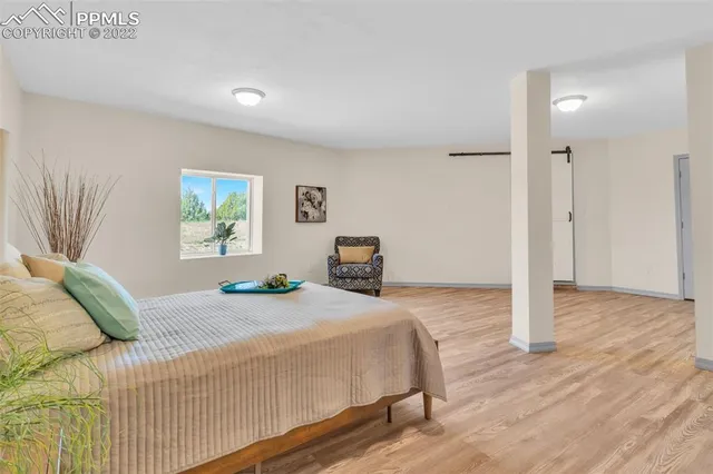 a bedroom with a bed and painting on the wall