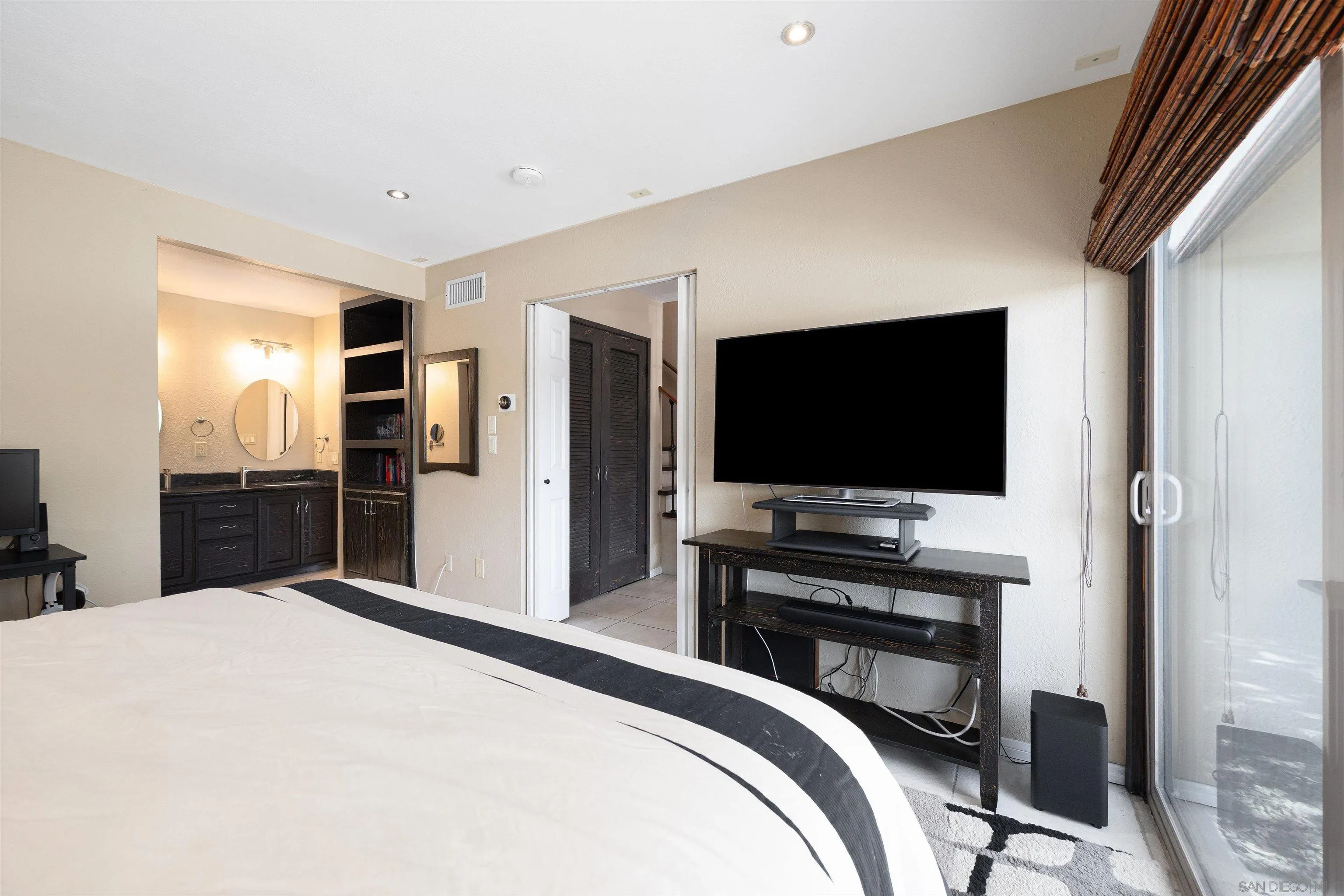 7700 Parkway Drive, Unit 4 La Mesa, CA 91942 - Photo 11 of 23 a bedroom with a bed and a flat screen tv