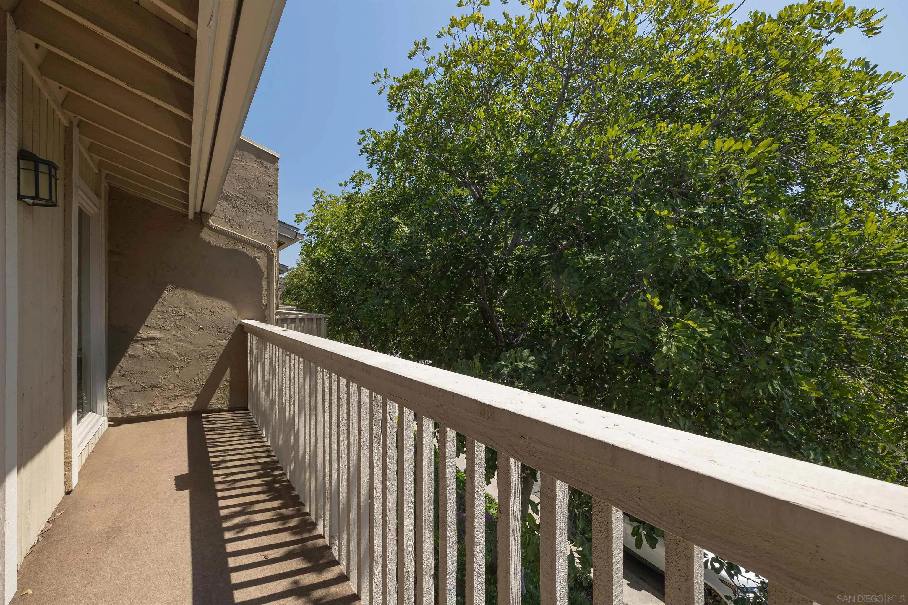 7700 Parkway Drive, Unit 4 La Mesa, CA 91942 - Photo 21 of 23 a side view of a balcony with wooden floor