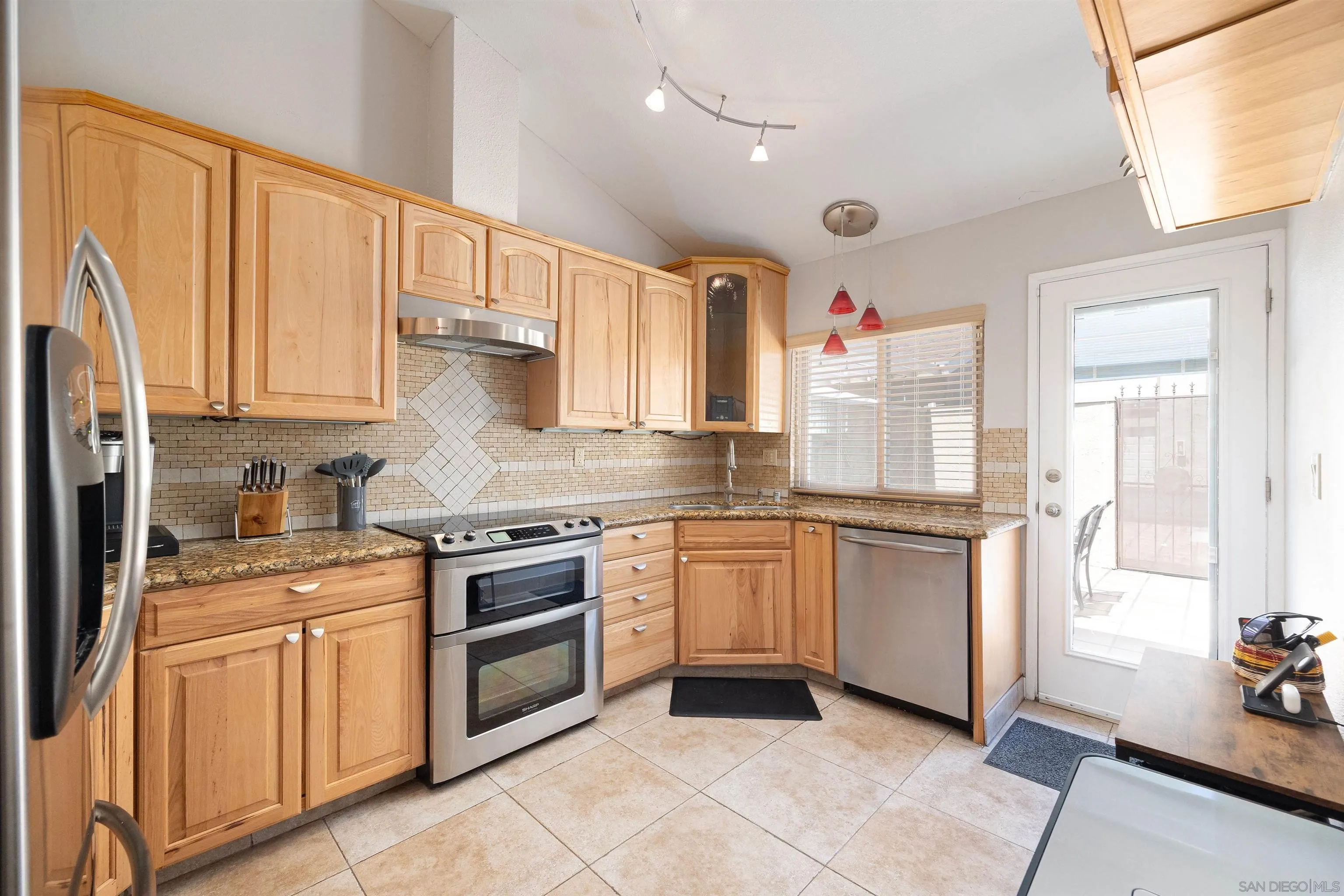 7700 Parkway Drive, Unit 4 La Mesa, CA 91942 - Photo 3 of 23 a kitchen with stainless steel appliances granite countertop a stove sink and cabinets