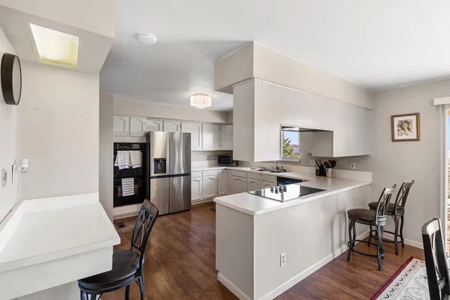 a kitchen that has a lot of cabinets a sink and appliances in it