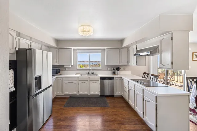 a kitchen with white cabinets appliances and sink