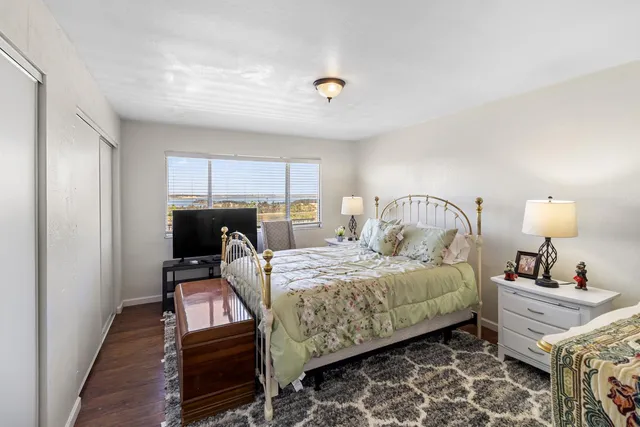 a bedroom with a bed and wooden floor
