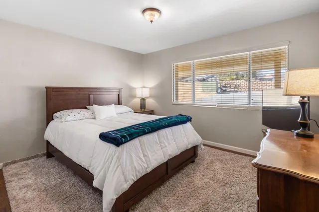 a large bed sitting in a bedroom next to a window