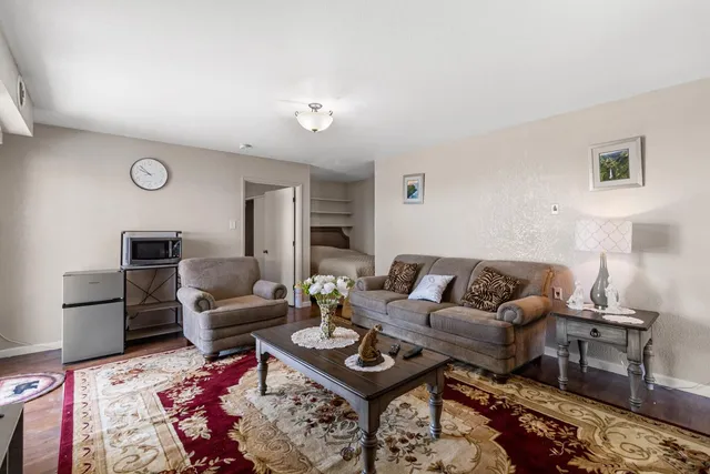 a living room with furniture a rug and a lamp